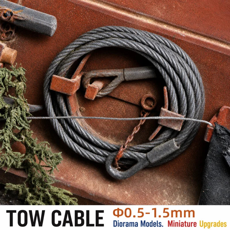 A coiled dark gray braided steel tow cable with metal clamps for scale models and scale modeling tools