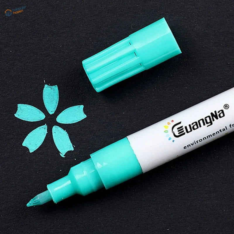 Teal guangna acrylic paint marker pen with white barrel on dark surface