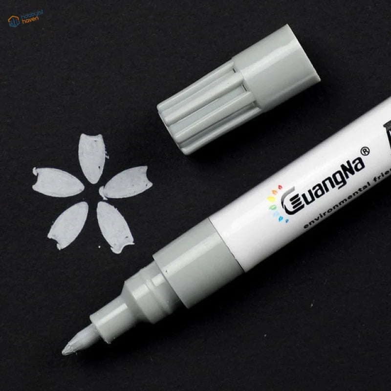 Sleek 0.7mm acrylic paint marker pen with fine tip, uncapped on dark surface
