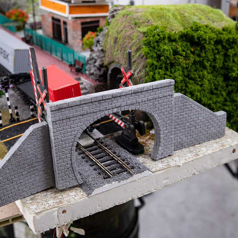 N scale gray stone tunnel portal with arch opening and red and white crossing gates for model railway scenery