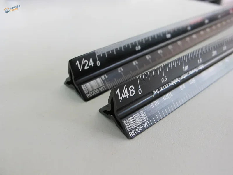 Black 1/12-1/72 triangular multi-scale ruler with white markings and barcodes