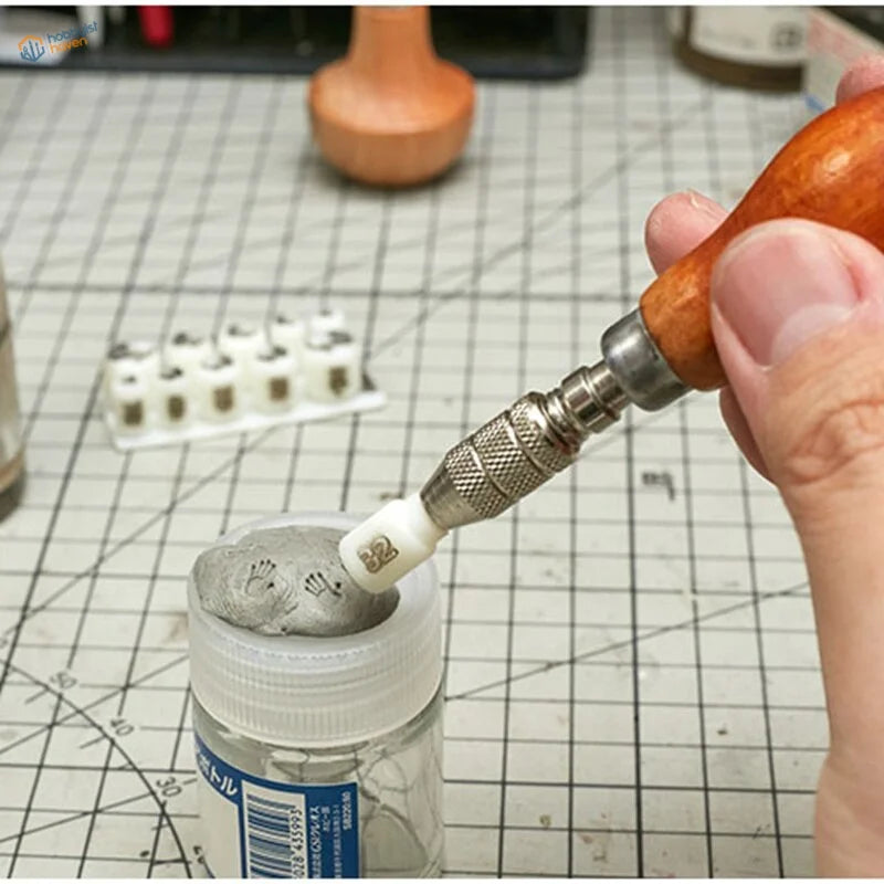 Hand using 3D printed handprint stamp to carve gray clay in jar