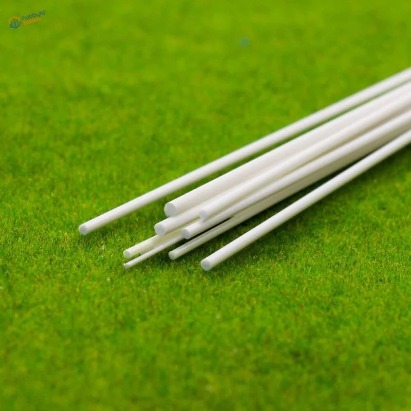 White styrene round rods on green textured surface