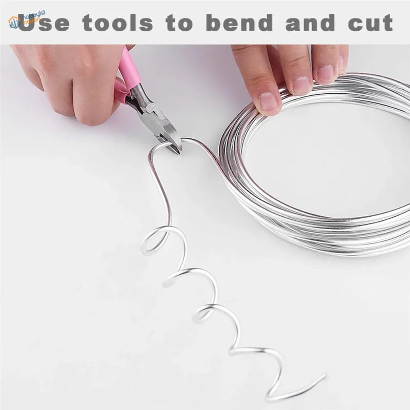 Coiled aluminum wire bent into spiral with pink pliers for scale modeling