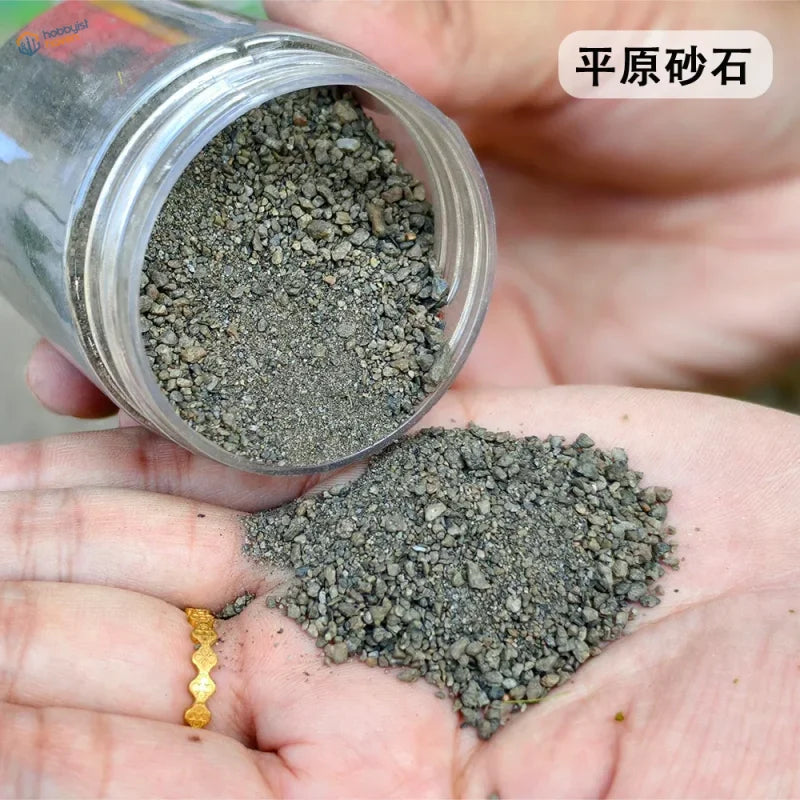 140ml HO/N railway ballast: gray gravel in clear plastic container over palm