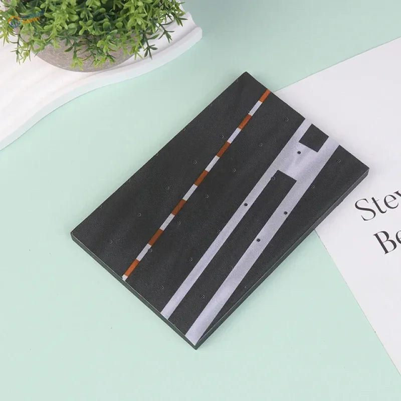 Black realistic runway base notebook with white orange road stripes