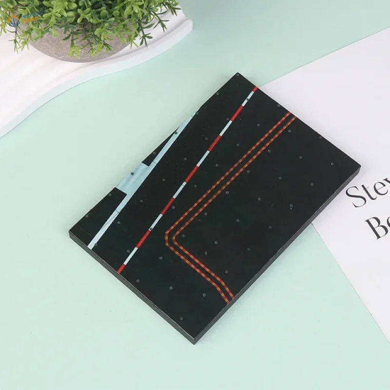 Black realistic runway base notebook with red white barriers orange stitching