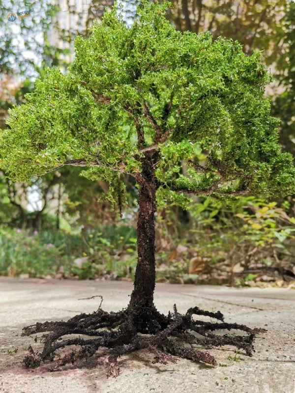 Scale model tree with a dense green canopy on a dark brown trunk