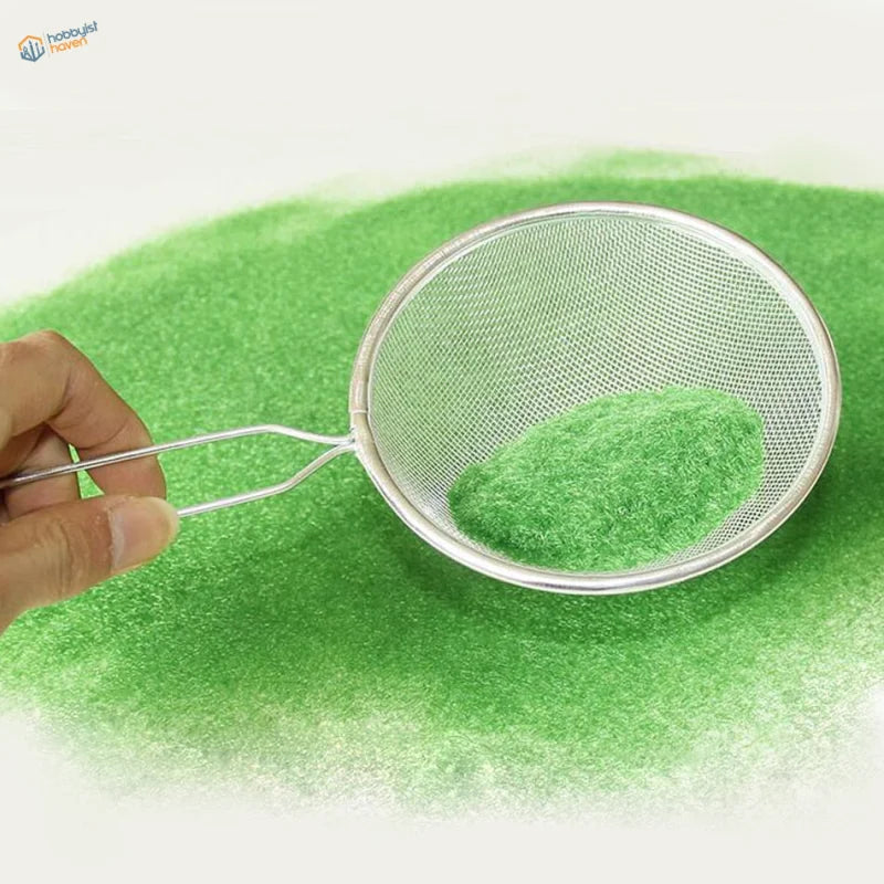 Silver sieve with long handle holding 2mm static grass powder green fluff