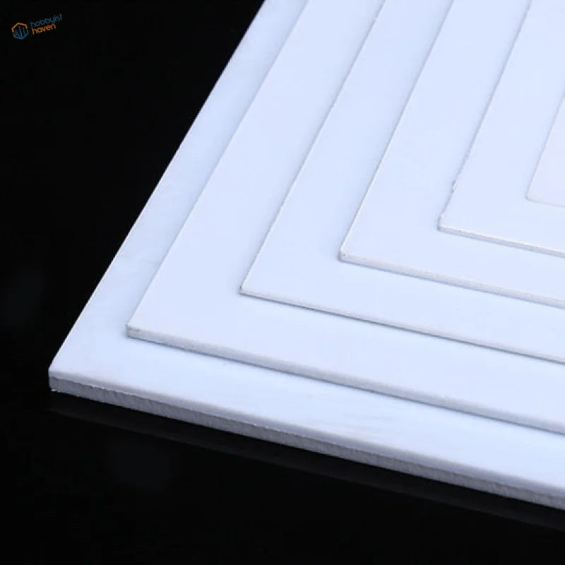 White styrene sheets stacked in descending sizes for scale models