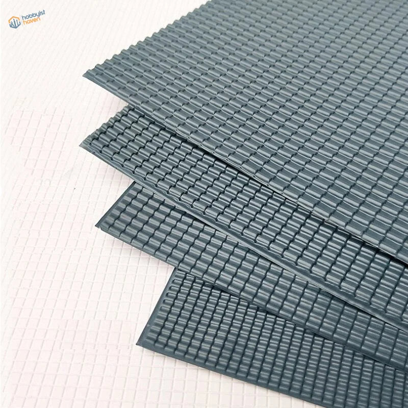 Stacked dark gray PVC roof panels with textured grid surface