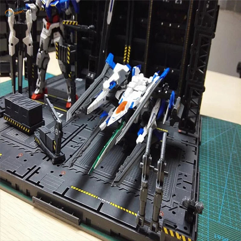 White and blue Gundam on mechanical base, black transport platform