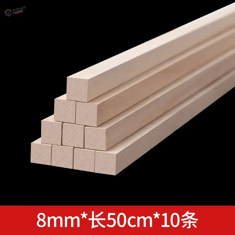 Light-colored balsa wood square rods stacked in pyramid formation