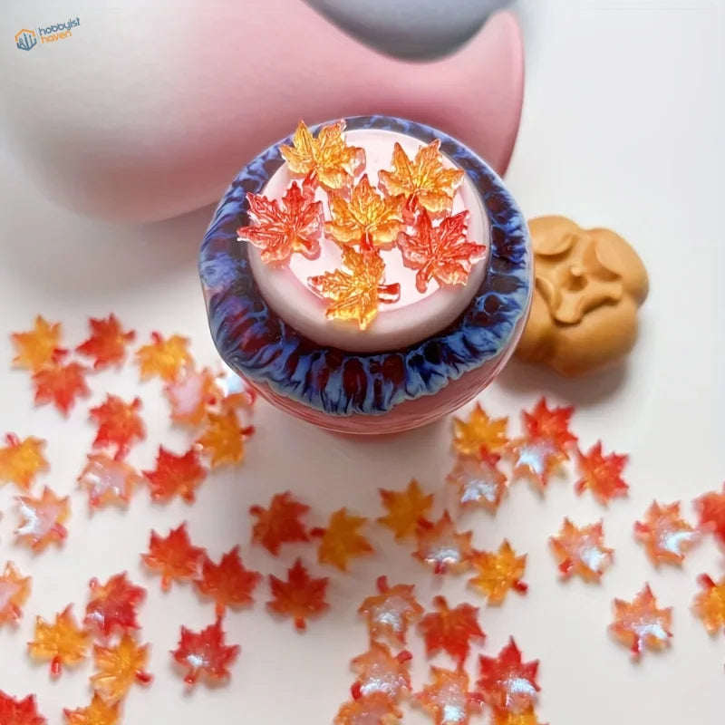 Translucent red maple leaves resin charms in pink-centered blue-rimmed container
