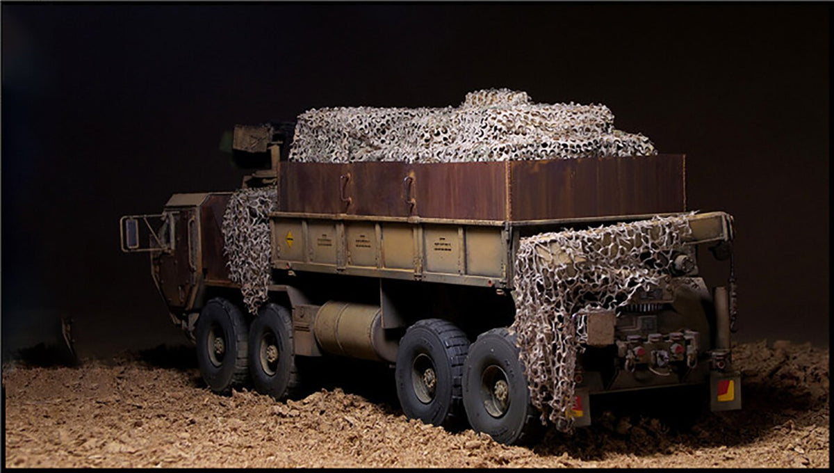 Detailed 1/35 military dump truck model with weathered paint and camouflage nets