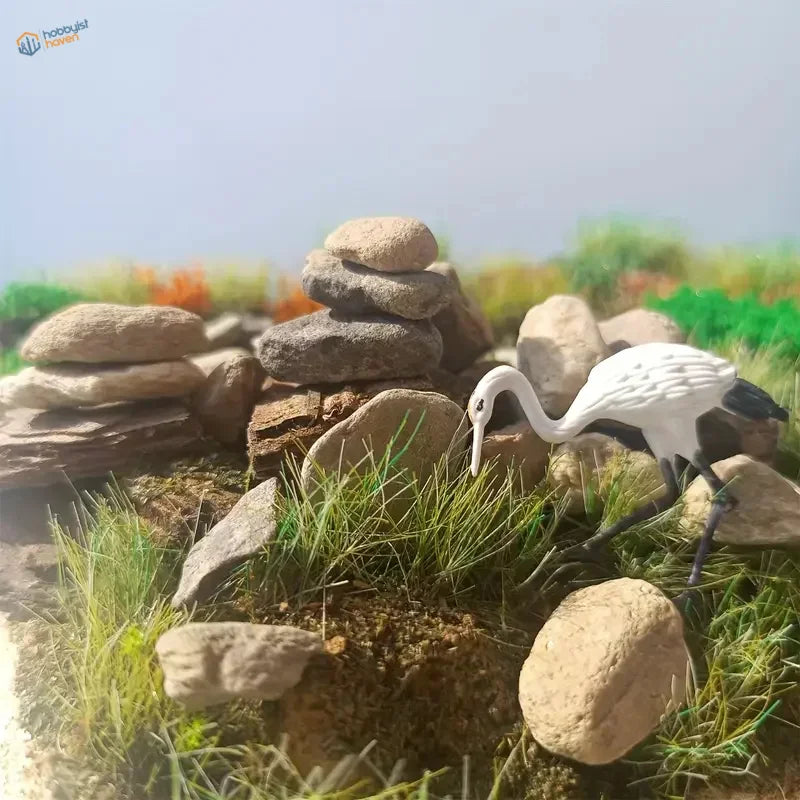 White black crane figurine on ballast gravel rocks stack