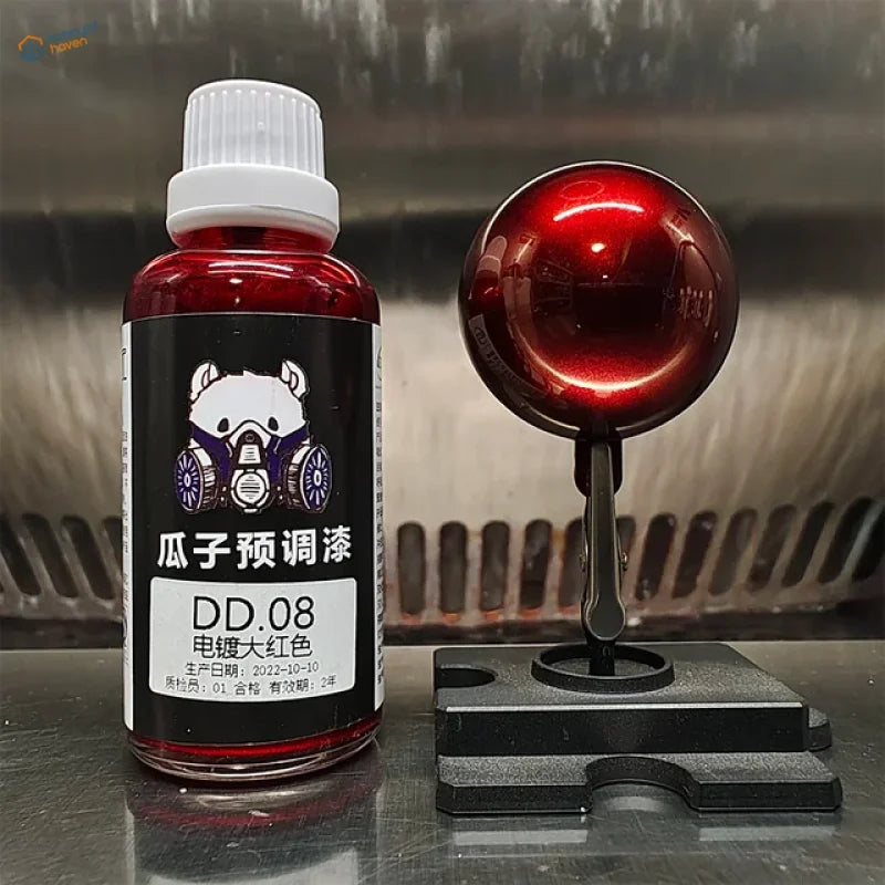 Metallic red electroplated mirror-chrome paint sphere beside a 50ml bottle
