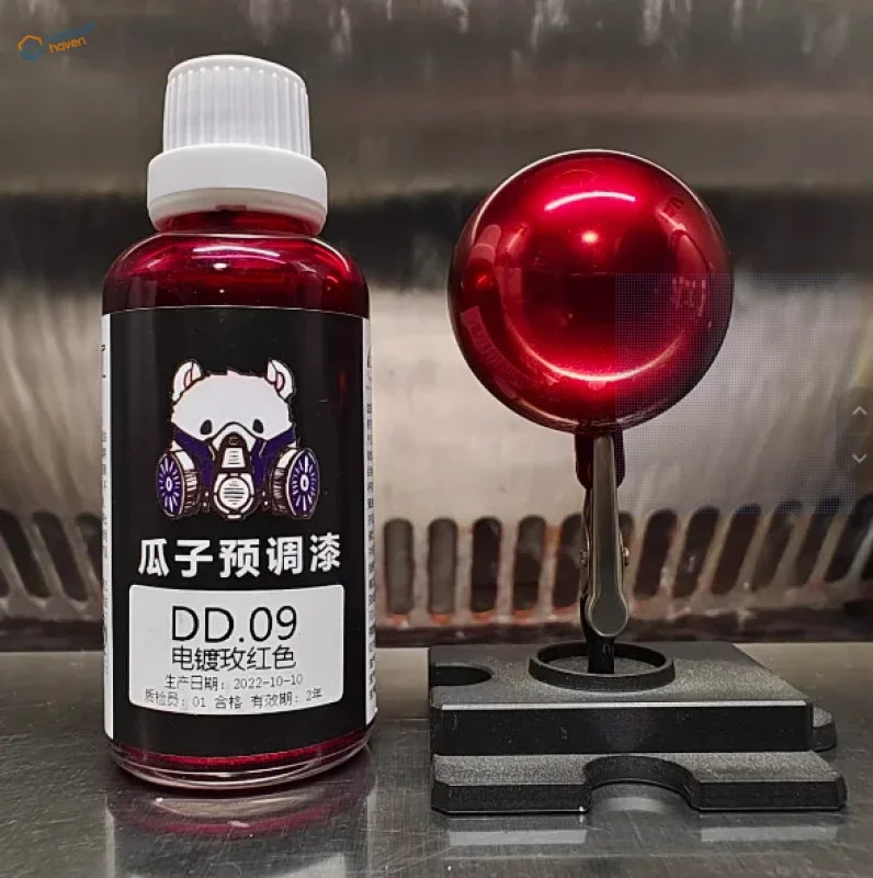 Rose red electroplated mirror-chrome paint sphere beside a 50ml bottle