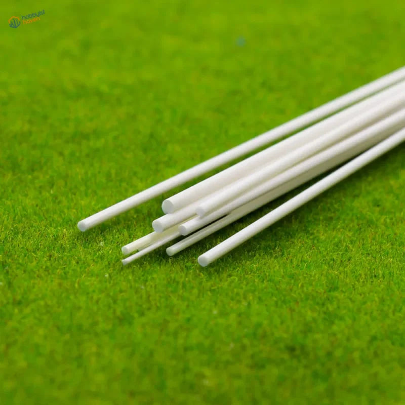 White styrene rods on green textured surface for scale modeling