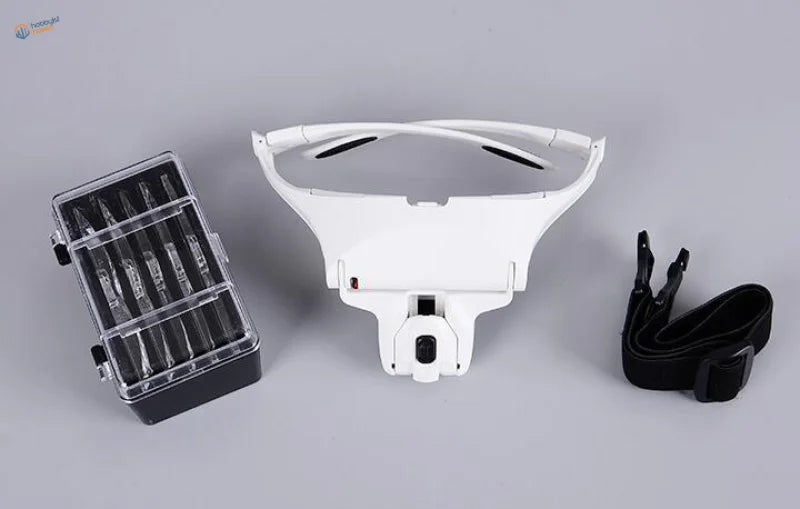 White plastic adjustable LED light headband magnifier with black strap