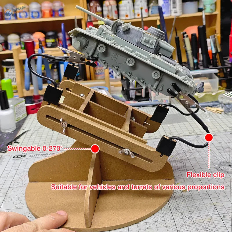Gray plastic model tank mounted on wooden adjustable painting stand with flexible clips for scale modeling tools use