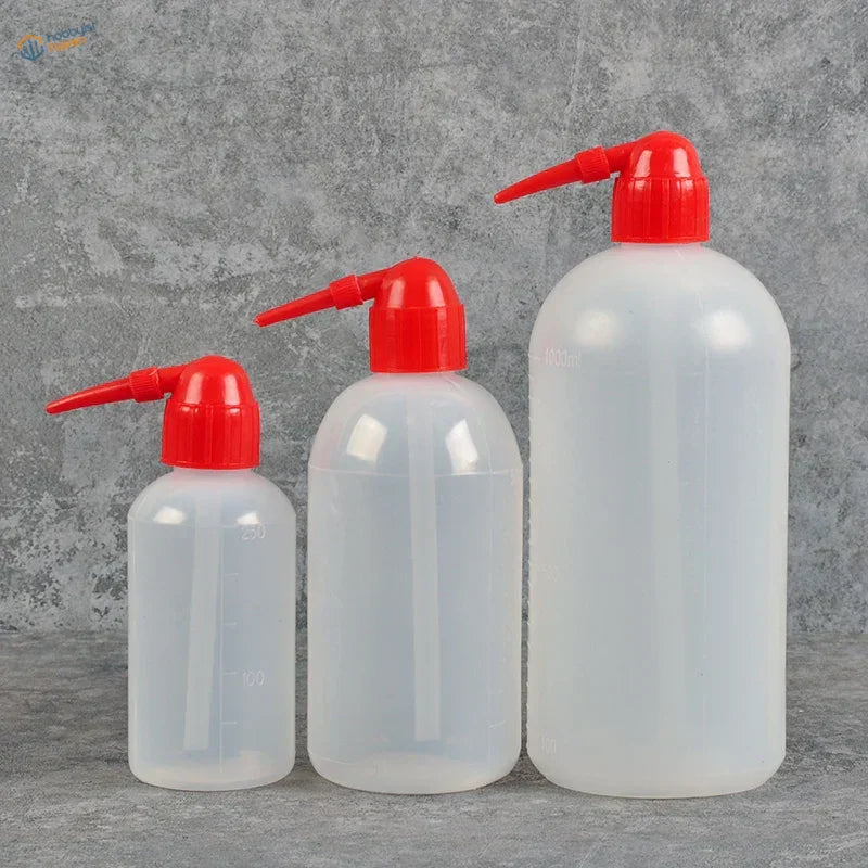 Three translucent airbrush cleaning bottles with red nozzles