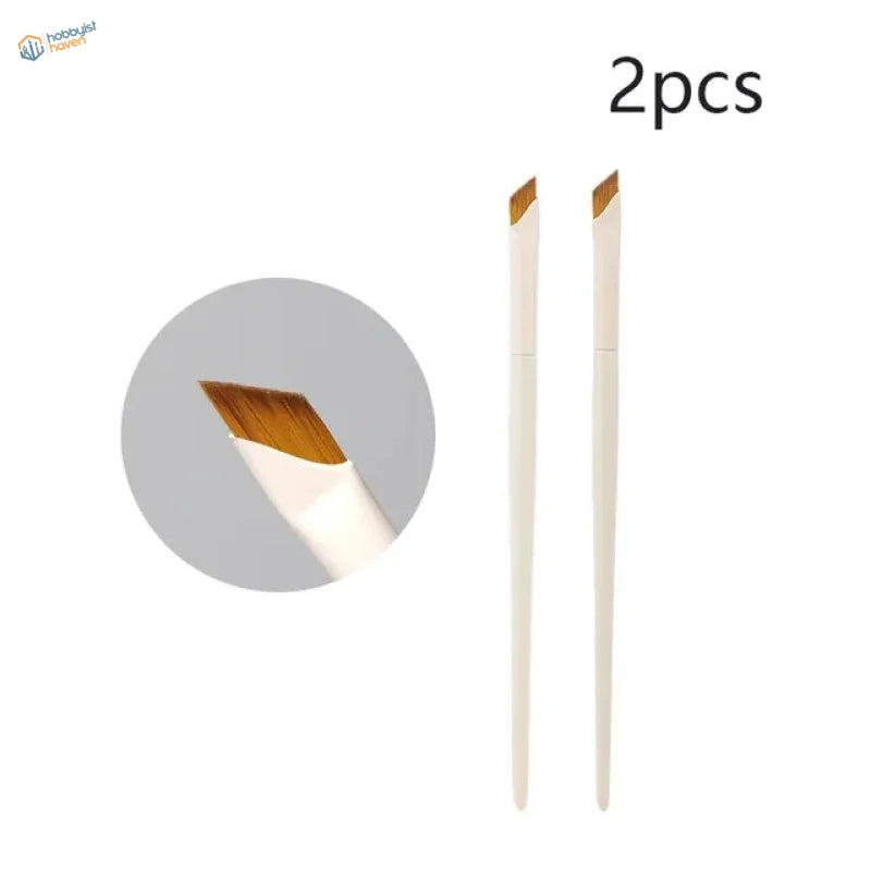 Angled liner brush with white handles and golden-brown bristles