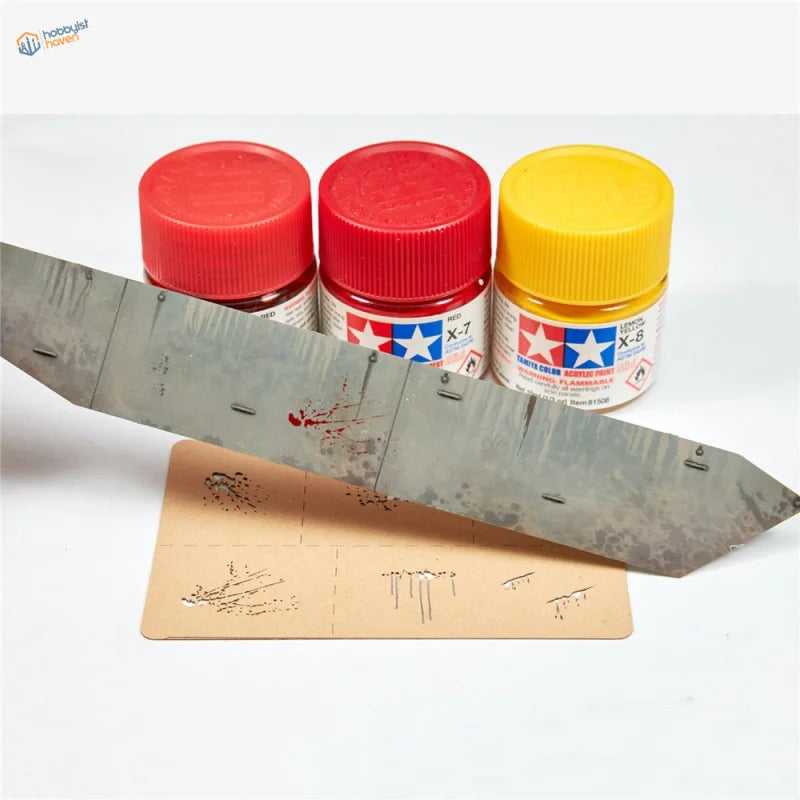 Three Tamiya paint bottles with assorted splashes effects stencil