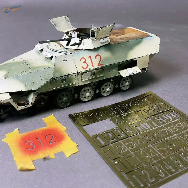 Olive green camo armored vehicle model with red 312 numeric stencils