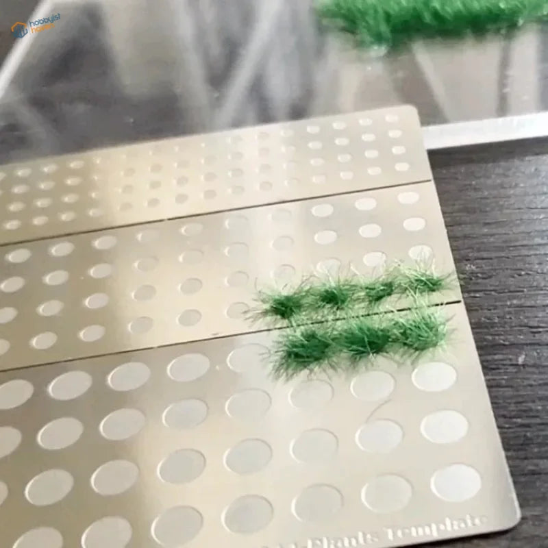 Green static grass tufts on Cormake static grass applicator perforated template