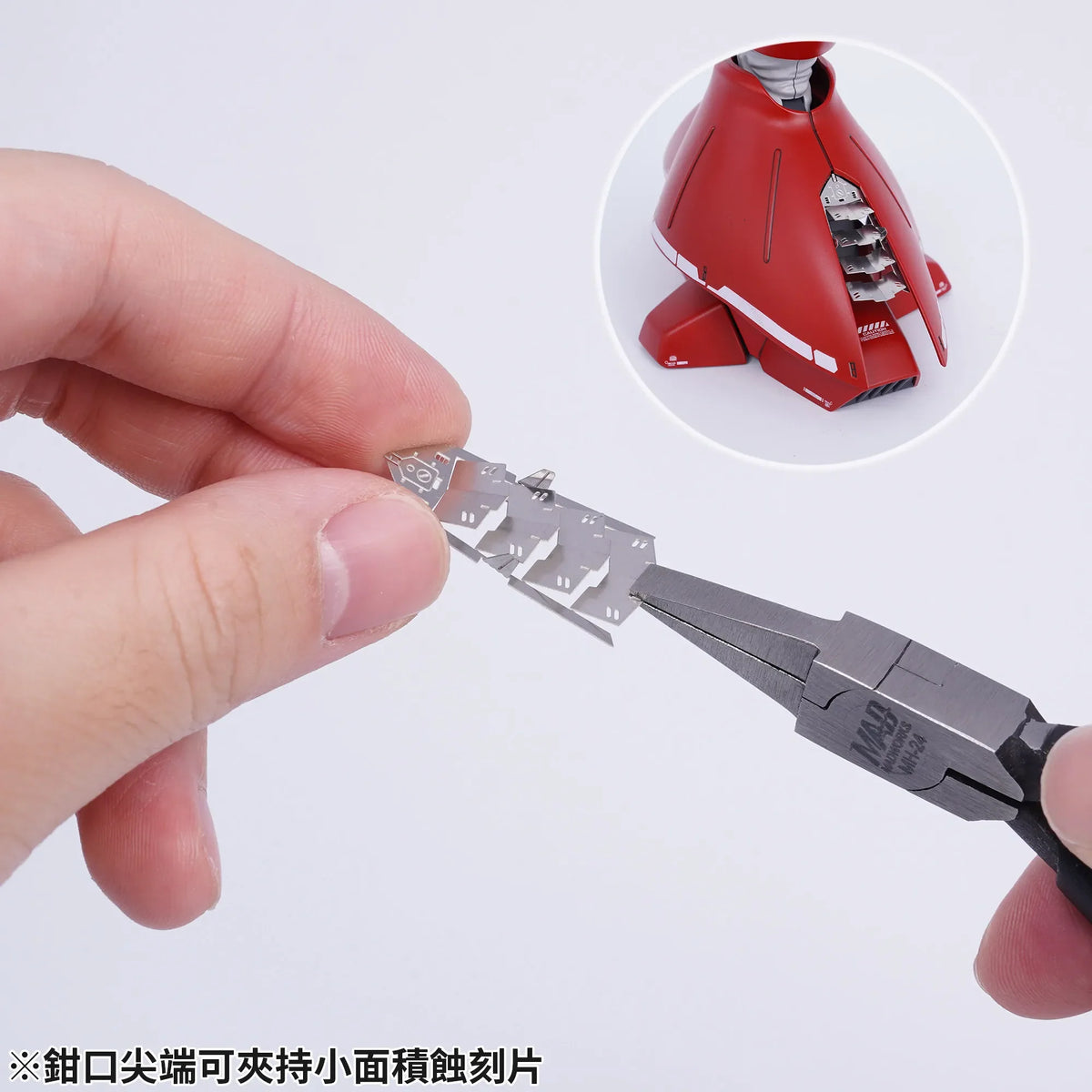 Silver metal model kit piece with intricate cutouts held by madworks flat nose bending pliers for precision hobby tools