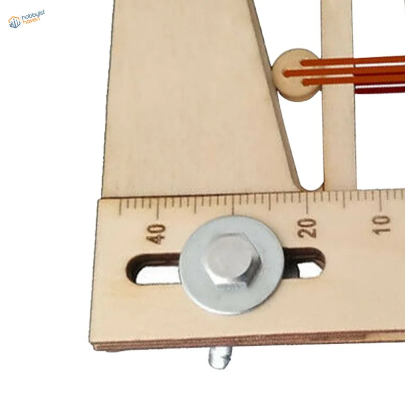Close-up of Deadeyes assembly tool base: engraved ruler scale and metal knob in the adjustment slot