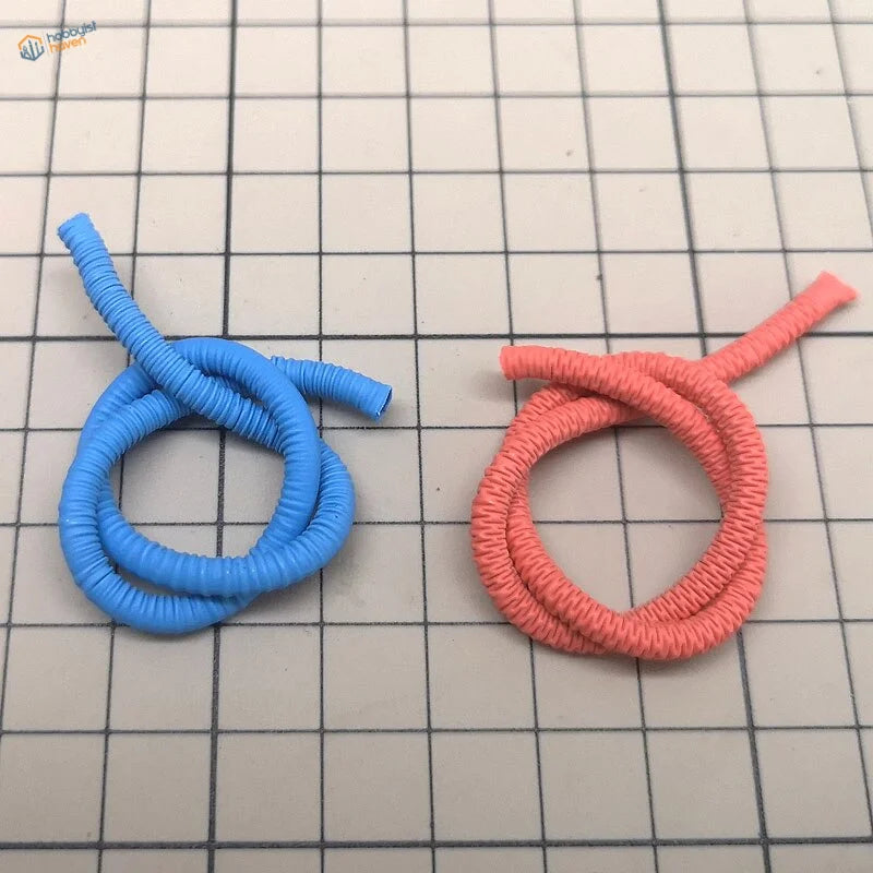 Two flexible oil pipes for Gundam: blue and coral pink coiled tubes on grid