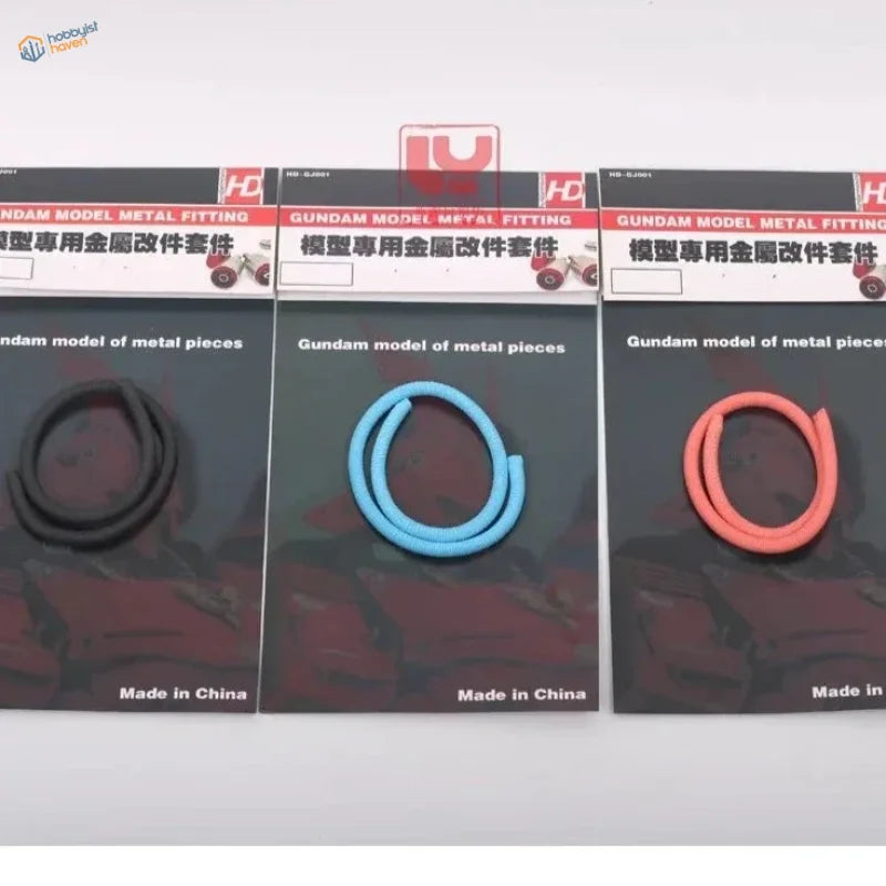 Three flexible oil pipes for Gundam in black, blue, orange on cards