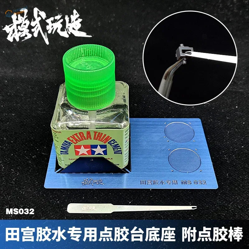 Green-capped Tamiya hobby glue in gluing stand with blue tray and applicator for scale modeling
