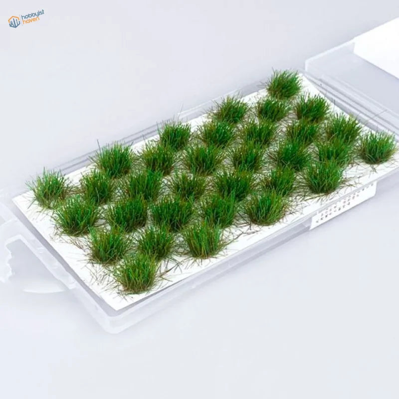Green artificial grass tufts in clear tray for grass flower patches