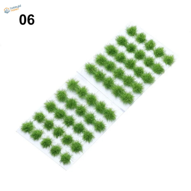 Green fuzzy grass flower patches in neat rows on white sheet, 60 models