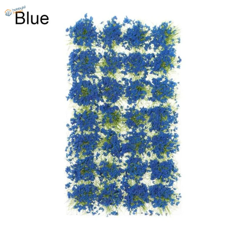 Blue artificial flower patches with green stems in dense grass cluster