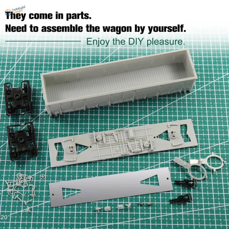Gray plastic ho scale 1:87 high-side gondola wagon parts on green cutting mat with model building tools for assembly