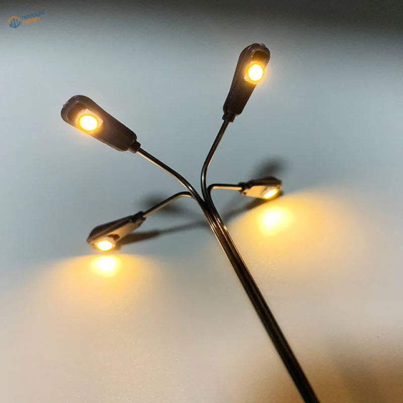 Ho scale LED street lamp with miniature black post and four glowing amber lights