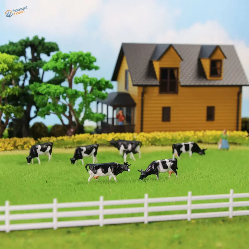 HO scale livestock farmers: black and white plastic cow figurines grazing