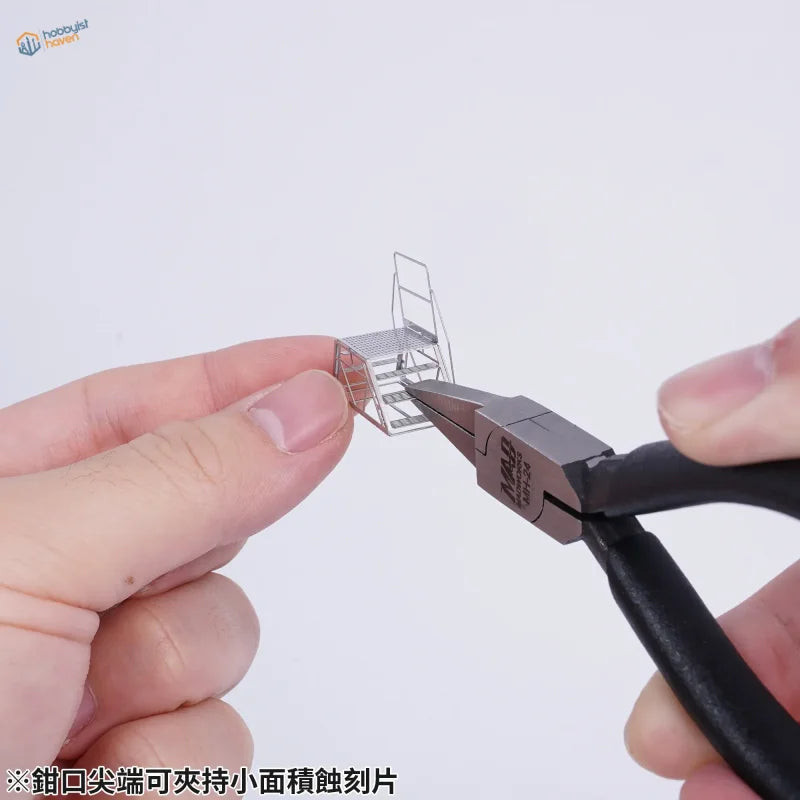 Silver metal miniature staircase held by Madworks flat nose photo etch bending pliers for precision hobby tools