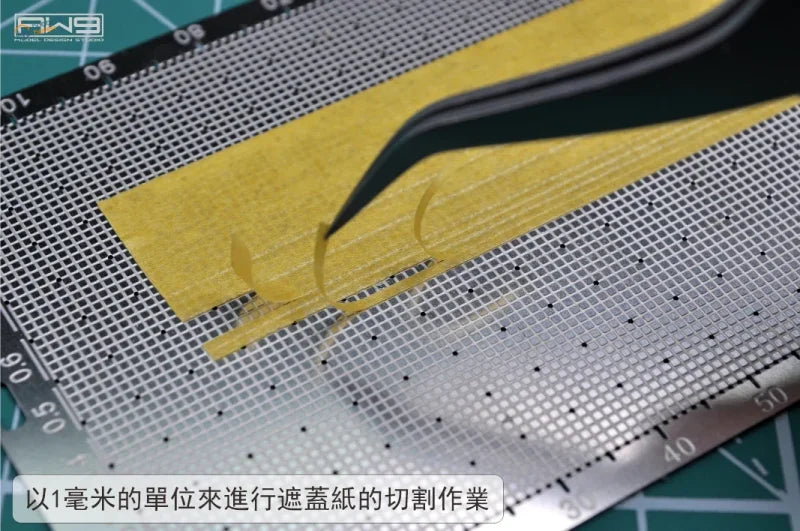 Black precision tweezers hold yellow masking tape strip over cutting template mat