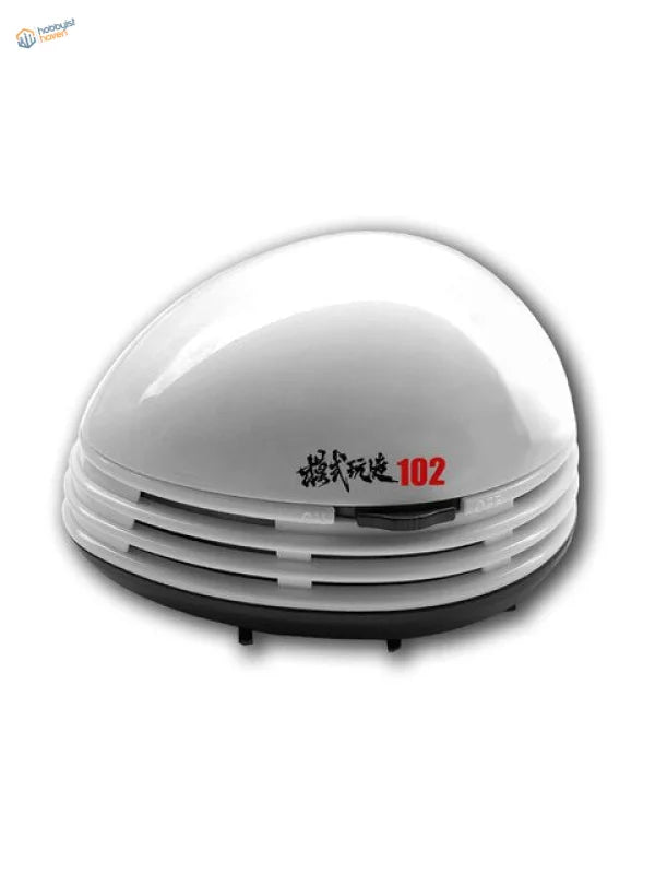 Mini desktop vacuum cleaner with white glossy dome and black slatted base