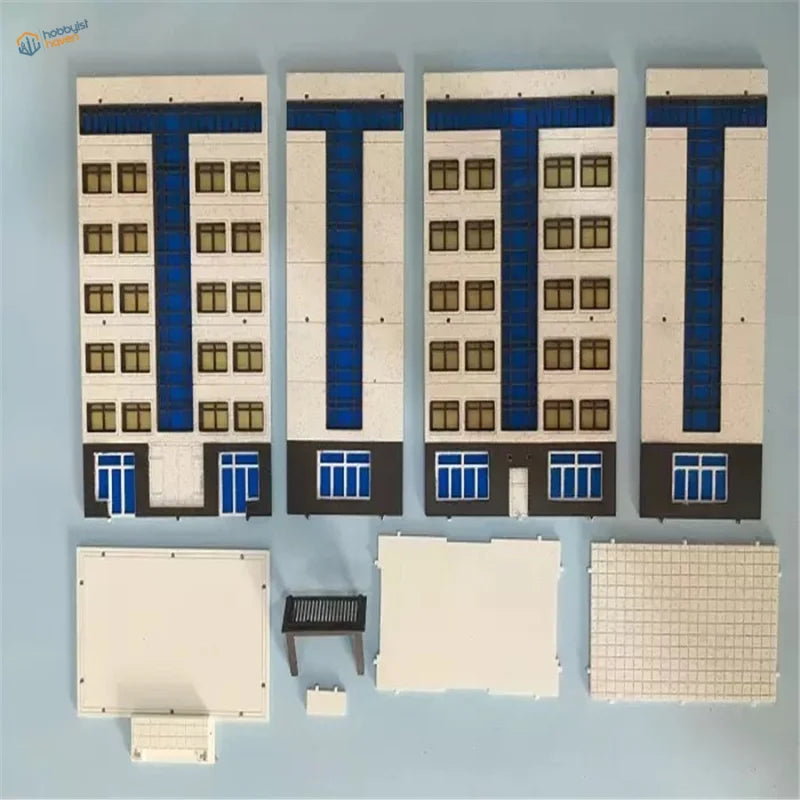 Four N scale building models in white, blue with brown window frames for railroad scenery