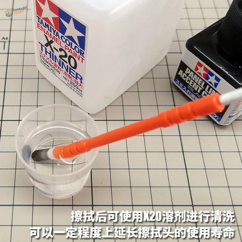 Orange-handled paintbrush in cup for Pigments and Paint Cleaning Pen