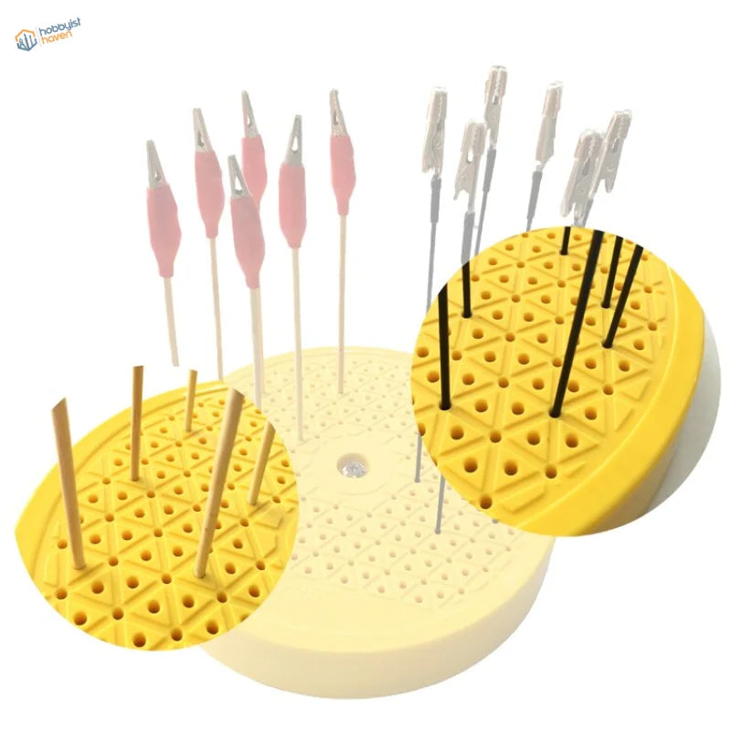 Yellow rotary painting turntable stand with triangular holes holding colored alligator clips