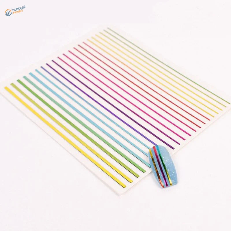 Rainbow stripe stickers on glittery blue nail with decals on white sheet