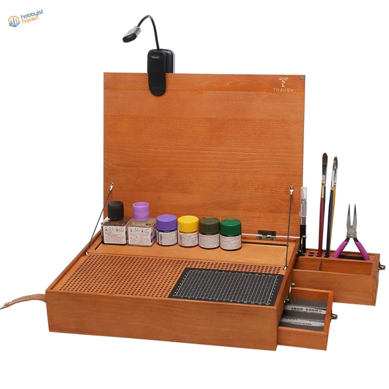 Wooden portable hobby station with led lamp and organized compartments holding paint jars and brushes for artists