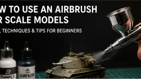 Close-up of an airbrush spraying a scale model for troubleshooting splatter